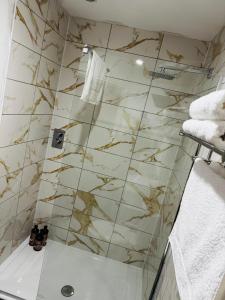 La salle de bains est pourvue d'une douche et de carrelage en marbre. dans l'établissement Selwyn Stays, à Liverpool 70 autres photos