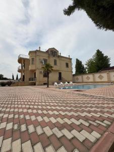 a building with a pool in front of a house at Super Villa in Mardakan