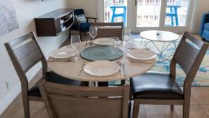 una mesa de comedor con platos y copas de vino en La Internacional 313 home, en South Padre Island 69 fotos más