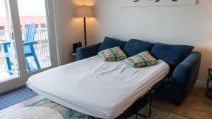 Cama en una sala de estar con sofá azul en La Internacional 313 home, en South Padre Island