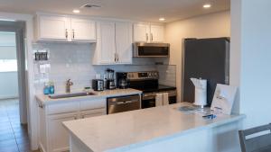 a kitchen with white cabinets and a black refrigerator at La Internacional 313 home in South Padre Island