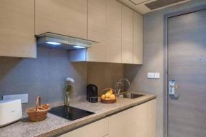 uma cozinha com um lavatório e uma taça de fruta no balcão em Golden glow in aipl joystreet em Gurgaon