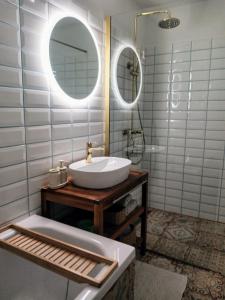 a bathroom with a sink and two mirrors at House Barci in Barci