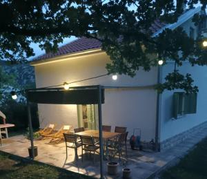 a patio with a table and chairs in front of a house at House Barci in Barci +28 photos