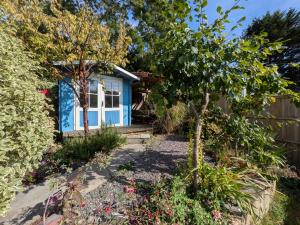 a blue house with a tree in a garden at Cherry View House 3 Bed Garden Parking sleeps 8 in Bristol