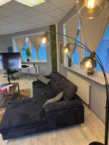 ein Wohnzimmer mit einem schwarzen Sofa und einem Klavier in der Unterkunft Stilvolles & klimatisiertes Loft mit Ausblick in die Ferne in Sankt Leon-Rot