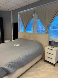 ein Schlafzimmer mit einem großen Bett und zwei Fenstern in der Unterkunft Stilvolles & klimatisiertes Loft mit Ausblick in die Ferne in Sankt Leon-Rot