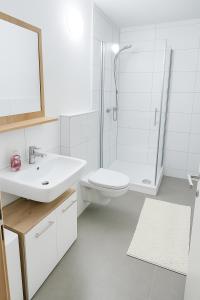 a white bathroom with a sink and a shower at Gemeinschaftsunterkunft Doppelzimmer für max 8P I 2 Bäder I Küche I einzeln oder komplett buchbar in Heidenheim