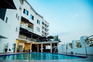 a hotel with a swimming pool in front of a building at Centric Hotel in Kigali