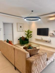 ein Wohnzimmer mit Couch und Flachbildfernseher in der Unterkunft Bright Modern2 bedroom Apr3 minutes away from a&c mall EAST LEGON in Trofwi + 19 Fotos