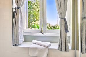 a window in a bathroom with towels on a window sill at Le jardin de Ponteves in Aix-en-Provence +20 photos