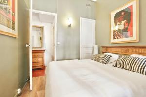 a bedroom with a white bed and a painting on the wall at Le jardin de Ponteves in Aix-en-Provence