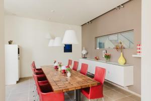 a dining room with a table and red chairs at B&B Asinello in Bruges