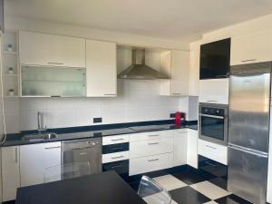 a kitchen with white cabinets and a black counter top at Apartamento independiente en Nigrán in Nigrán