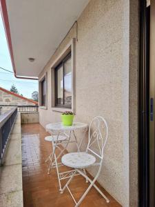 a table and chairs on the balcony of a house at Apartamento independiente en Nigrán in Nigrán