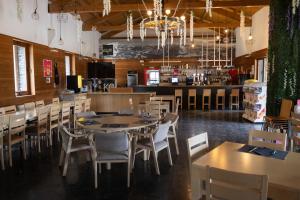 a dining room with tables and chairs and a bar at KYOMU Resort in Velilla del Río Carrión