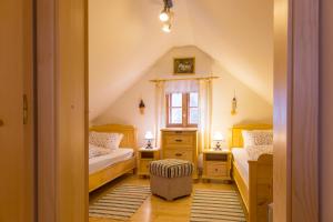 a attic bedroom with two beds and a window at Na mú dušu - Valašské chalupy na Kyčerce in Velké Karlovice