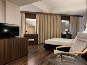 a hotel room with a bed and a television at The Landmark Hotel in Batu Pahat