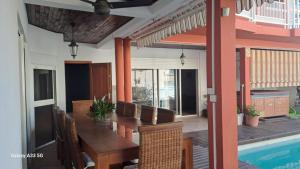 a dining room with a table and a swimming pool at Villa Soazara in Koungou