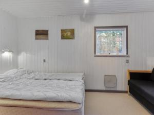 a bedroom with a white bed and a window at Holiday Home Teofilka - 200m from the sea by Interhome in Sæby +10 photos