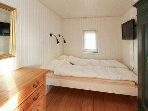 a bedroom with a large white bed with a window at Holiday Home Jenson - 75m from the sea by Interhome in Sæby +13 photos