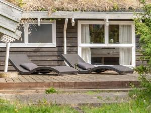 a couple of chairs sitting on a wooden deck at Holiday Home Alfi - 150m from the sea by Interhome in Sæby