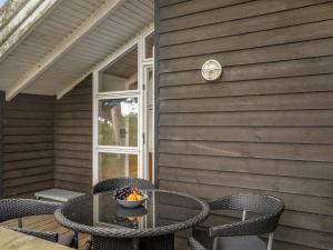 a patio with a table and chairs and a window at Holiday Home Alfi - 150m from the sea by Interhome in Sæby +20 photos
