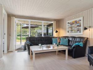 a living room with a leather couch and a coffee table at Holiday Home Inan - 300m from the sea by Interhome in Hals
