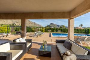 a patio with furniture and a swimming pool at Spacious villa for 10 with private pool in El Port
