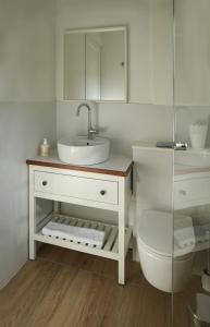 a white bathroom with a sink and a toilet at Stou Savvide - Pera Pedi Stone Manor in Perapedhi +41 photos