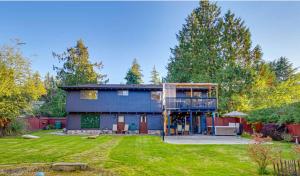 a blue house with a balcony and a yard at Family Paradise Hot Tub, Fire Pit n Play House in Mount Vernon