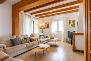 a living room with a couch and a tv at Spacious villa for 10 with private pool in El Port