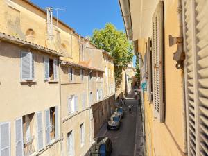 eine Gasse mit Autos, die auf einer Straße zwischen Gebäuden geparkt sind in der Unterkunft Refuge reposant - Centre ville - Espace Bureau in Aix-en-Provence