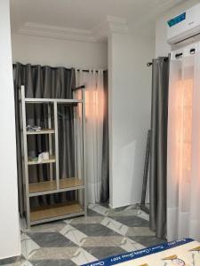 a room with gray curtains and a shelf at 2 cozy bedrooms in Lomé Sagbado in Komé