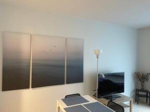 a living room with a tv and a table at Modern 1 bedroom apartment with a patio in Turku +2 photos