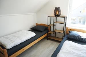 1 dormitorio con 2 camas y estante para libros en Kustverhuur, Vakantiepark Fort Soleil 28, en Breskens