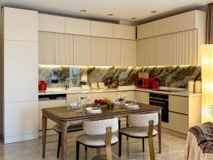 une cuisine avec une table et des chaises en bois dans l'établissement Qoople Legend C9 - Luxury apartment in Alanya, à Alanya