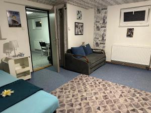 a bedroom with a bed and a couch and a chair at Apartmány MK u MODRÉ KOČKY in Nové Hrady