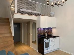 a kitchen with white cabinets and a black counter top at Cozy Loft next to Old Town in Tallinn