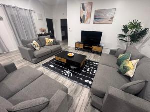 a living room with two couches and a tv at Te Kopa Villa in Rarotonga
