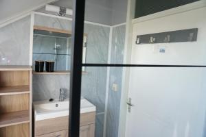 un baño con lavabo y ducha en Kustverhuur, Vakantiepark Fort Soleil 28, en Breskens 28 fotos más
