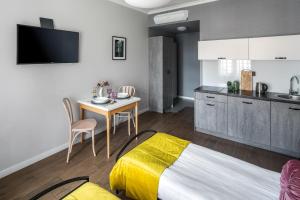a bedroom with a bed and a table and a kitchen at Wavelo Apartments in Kraków +14 photos