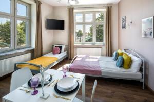 a small room with a bed and a table with a table sidx sidx at Wavelo Apartments in Kraków