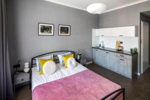 a bedroom with a large bed with yellow and white pillows at Wavelo Apartments in Kraków