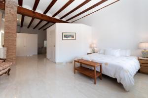 a white bedroom with a large bed and a table at Penthouse Duplex 4 PAX by costablancarent in Denia