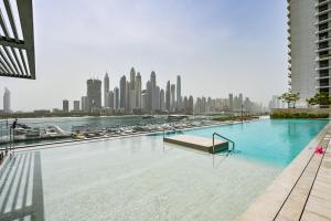 une grande piscine avec une vue sur les toits de la ville en arrière-plan dans l'établissement Luxury 2BR Retreat Gorgeous Beach & Skyline Views, à Dubaï