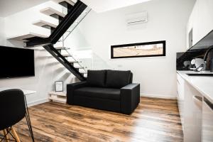a black chair in a living room with a staircase at Loft Prestige in Leiria
