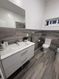 a bathroom with a white sink and a toilet at Te Kopa Villa in Rarotonga +20 photos