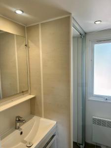 a bathroom with a sink and a mirror and a window at Domaine Le Petit Lac in Moustiers-Sainte-Marie