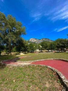 a red circle in a park with a mountain in the background at Domaine Le Petit Lac in Moustiers-Sainte-Marie +4 photos